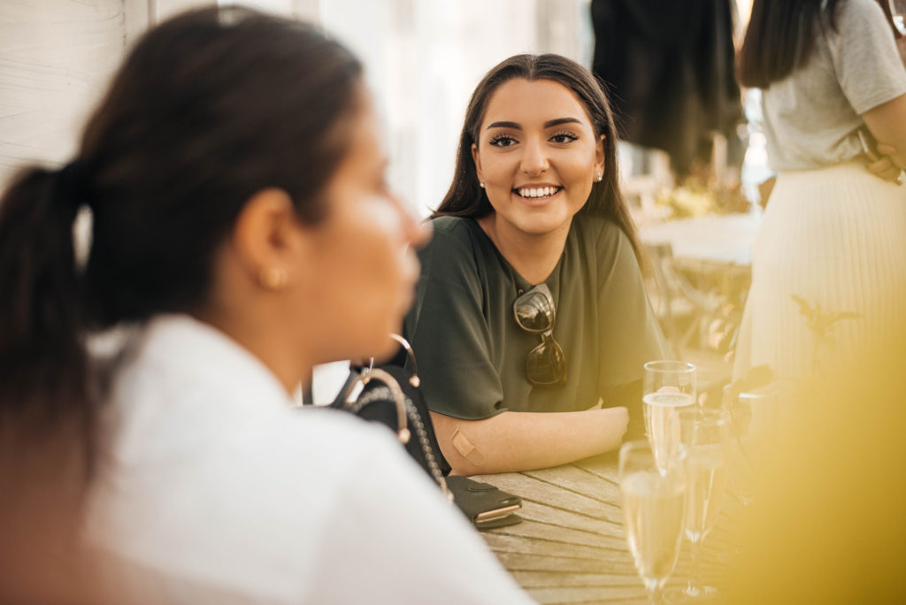 smiling person sitting by a table