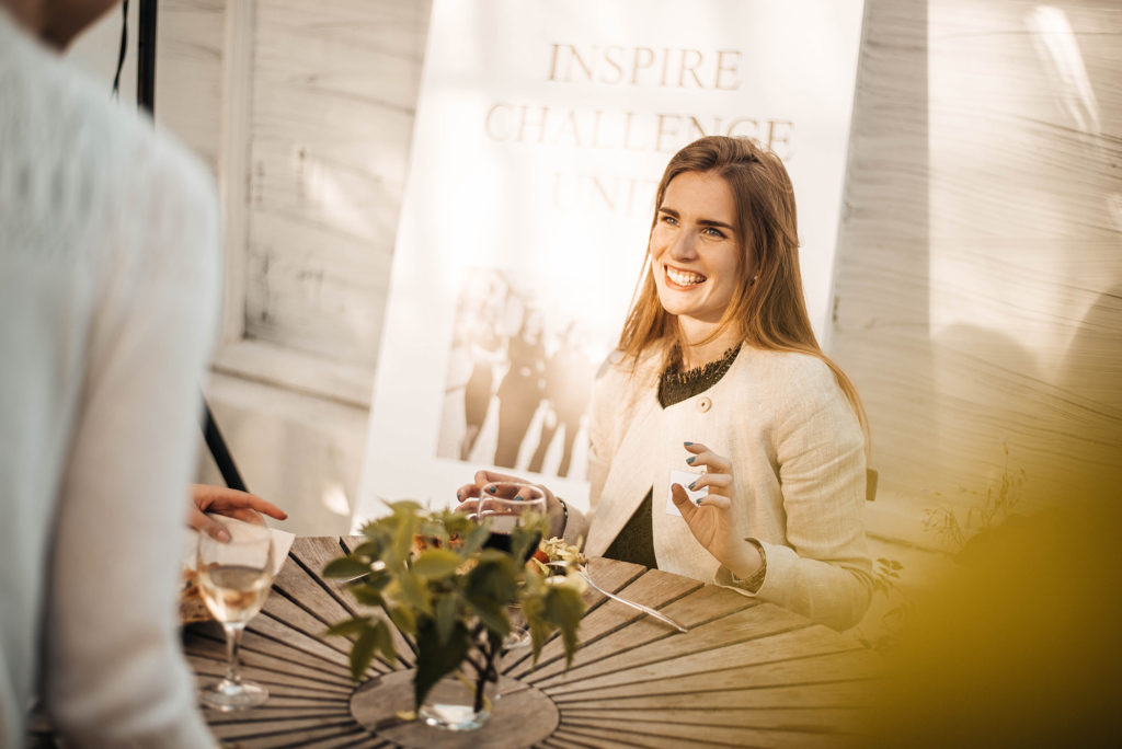 smiling person sitting by a table