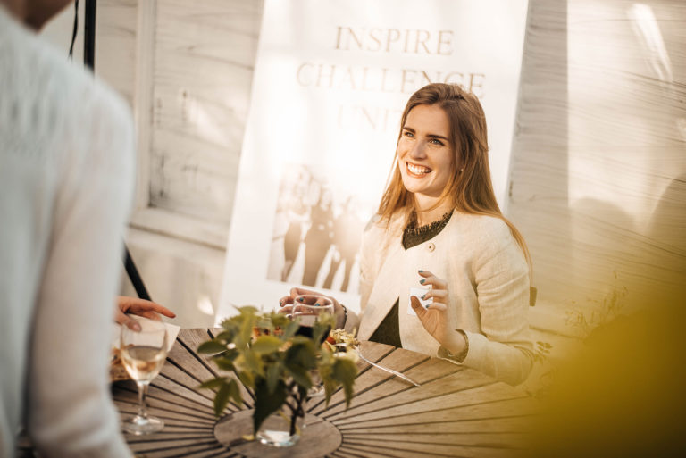 smiling person sitting by a table